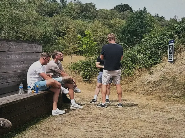Members chatting between rounds in the summer sun