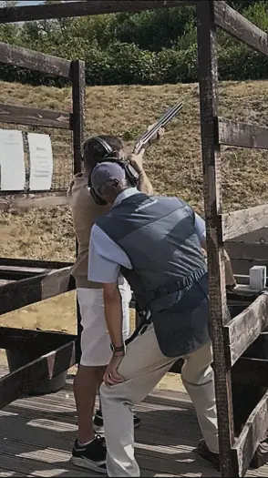 A member taking aim with an instructor beside him