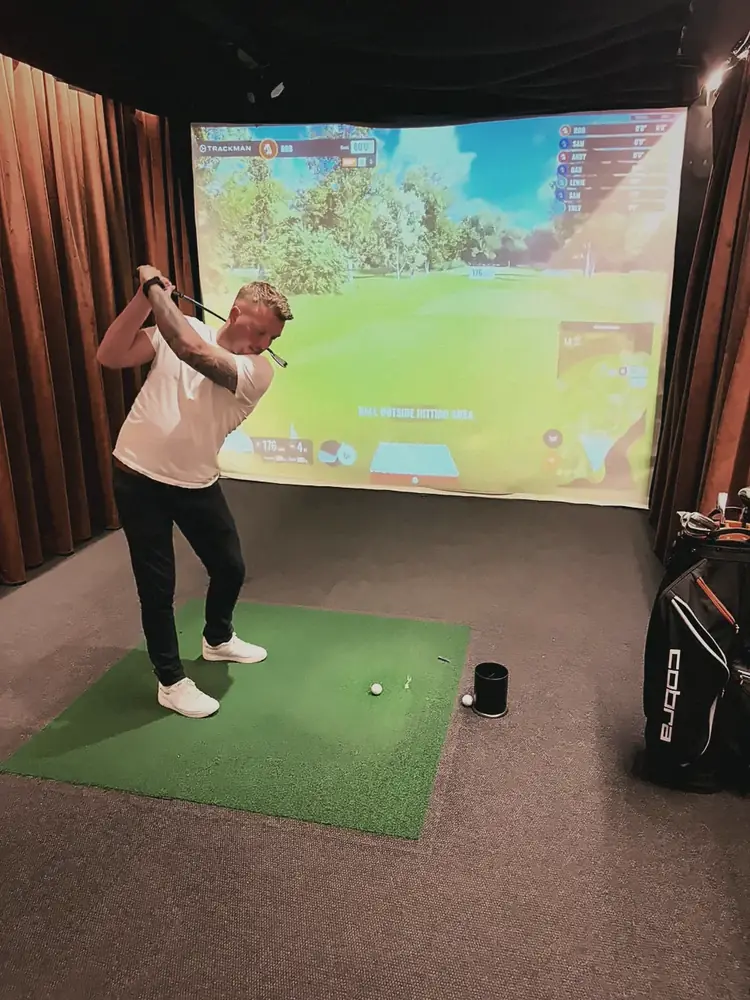 A member taking a swing on a golf simulator at Pitch